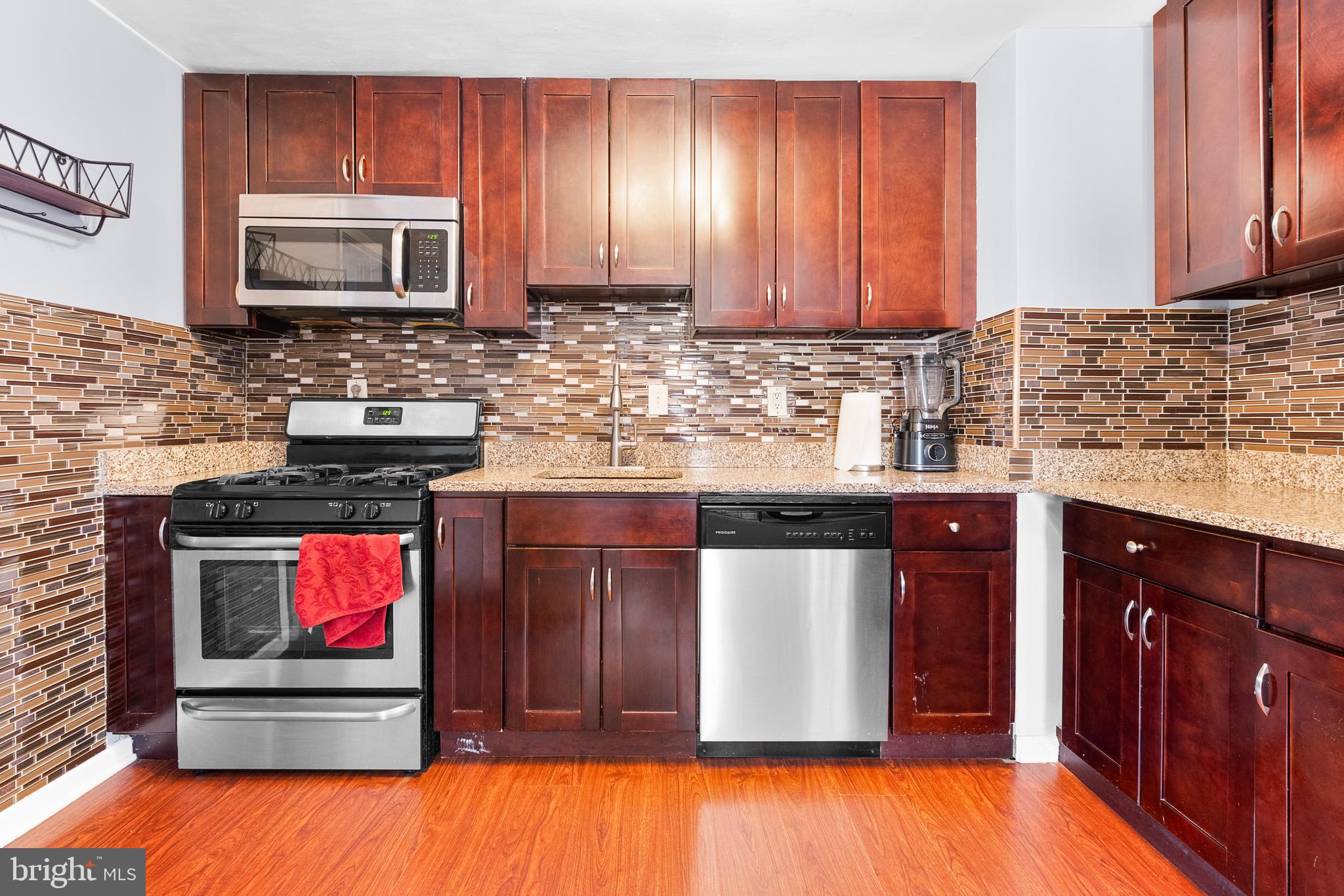 2208 Virginia Avenue Landover, MD 20785 - Photo 7 of 17 a kitchen with stainless steel appliances granite countertop wooden cabinets a stove top oven a sink and dishwasher