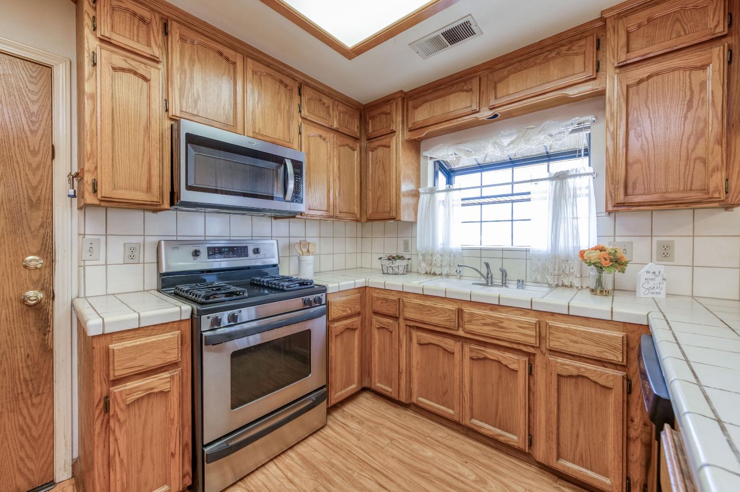 19650 Road 31 Madera, CA 93638 - Photo 12 of 43 a kitchen with cabinets stainless steel appliances a sink and a microwave