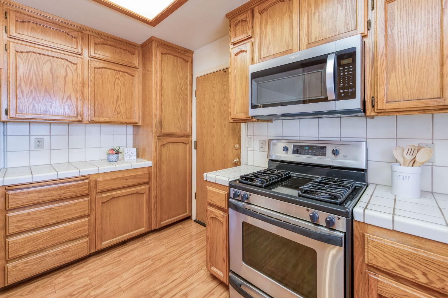 19650 Road 31 Madera, CA 93638 - Photo 14 of 43 a kitchen with stainless steel appliances granite countertop a stove microwave and cabinets
