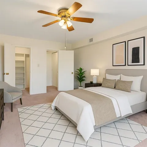 an empty room with windows and fan