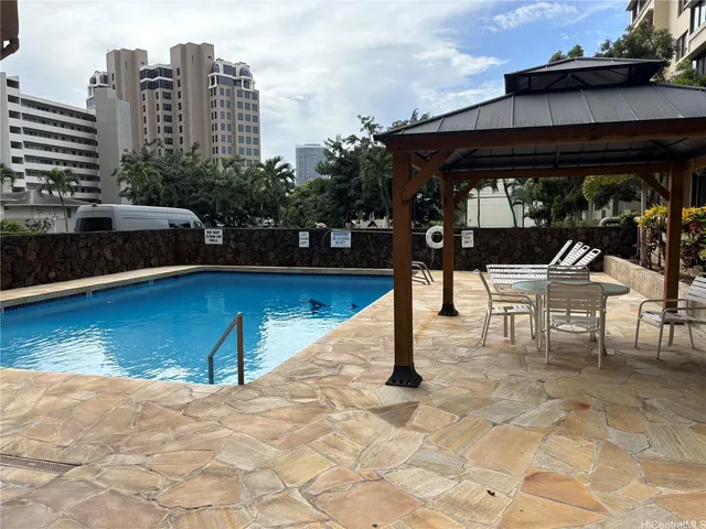 a view of a patio with a table chairs and a barbeque
