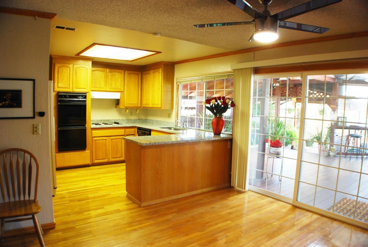 3381 Tully Road San Jose, CA 95148 - Photo 7 of 17 a view of a kitchen with kitchen island stainless steel appliances wooden floor and view living room