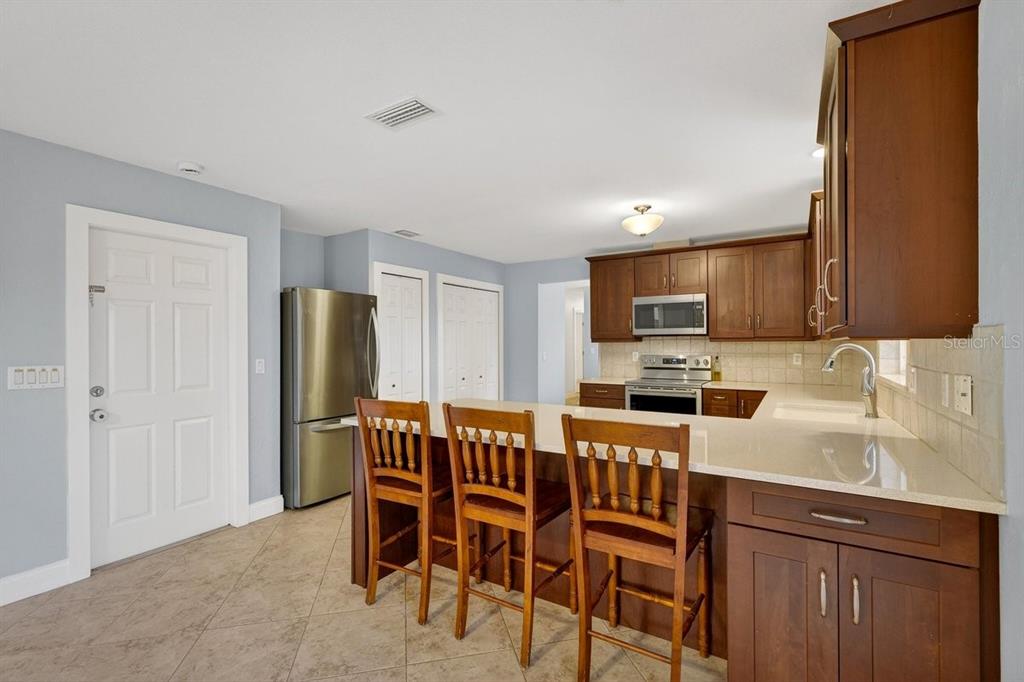 720 Pringle Road Port Orange, FL 32127 - Photo 43 of 68 a kitchen with stainless steel appliances a sink a stove a refrigerator cabinets and dining table