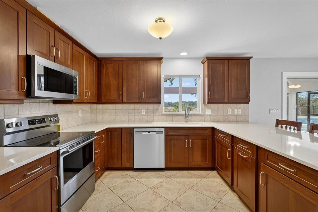 720 Pringle Road Port Orange, FL 32127 - Photo 45 of 68 a kitchen with stainless steel appliances granite countertop a sink and dishwasher a stove top oven with wooden floor