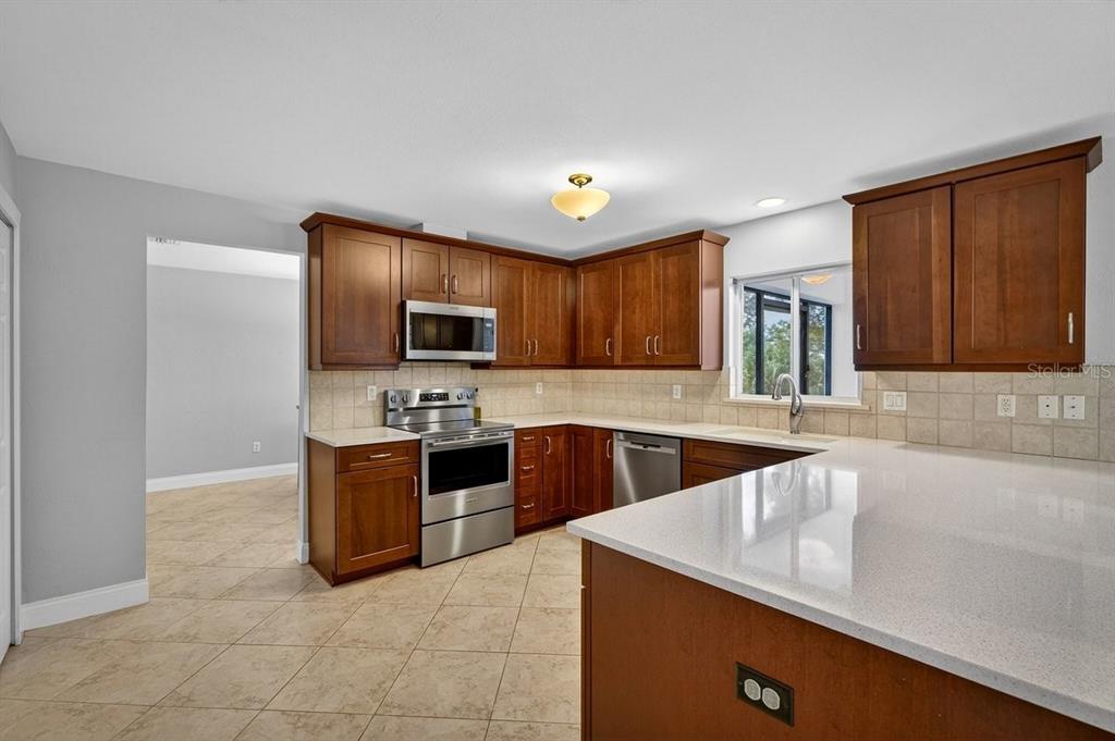 720 Pringle Road Port Orange, FL 32127 - Photo 47 of 68 a large kitchen with stainless steel appliances granite countertop a sink and cabinets