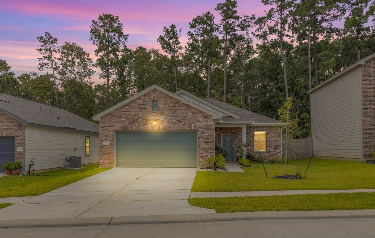 a front view of a house with a yard and trees