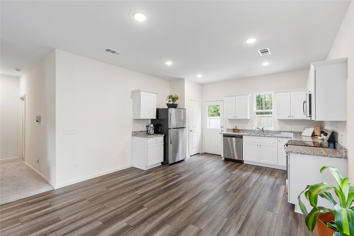 3626 Addington Ct. Huffman, TX 77336 - Photo 10 of 26 a kitchen with a wooden floor window and stainless steel appliances