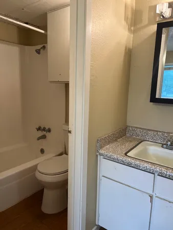 a bathroom with a granite countertop sink toilet and shower