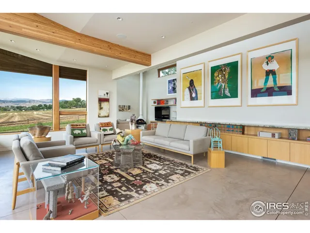 a living room with furniture large window and rug