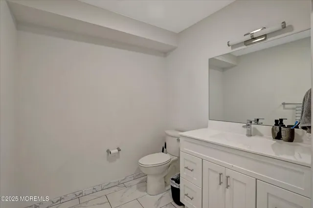 a bathroom with a toilet a sink and mirror