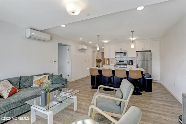 a living room with a couch and a dining table with wooden floor