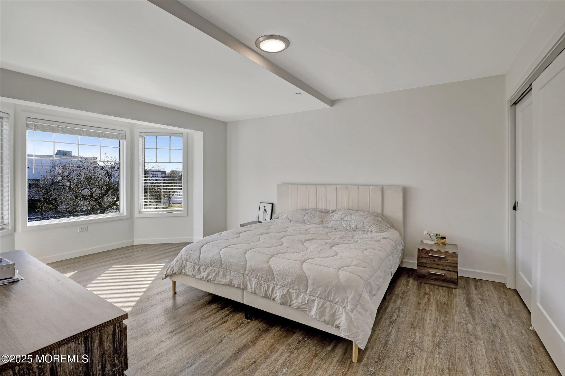 55 Brighton Avenue, Unit 4 Long Branch, NJ 07740 - Photo 8 of 33 a bedroom with a bed and wooden floor