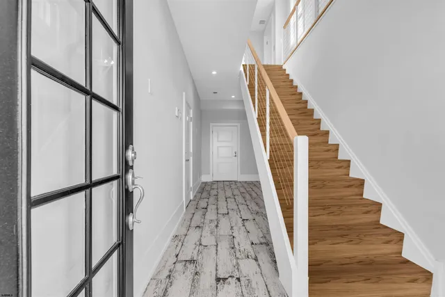 a view of staircase with wooden floor and white walls