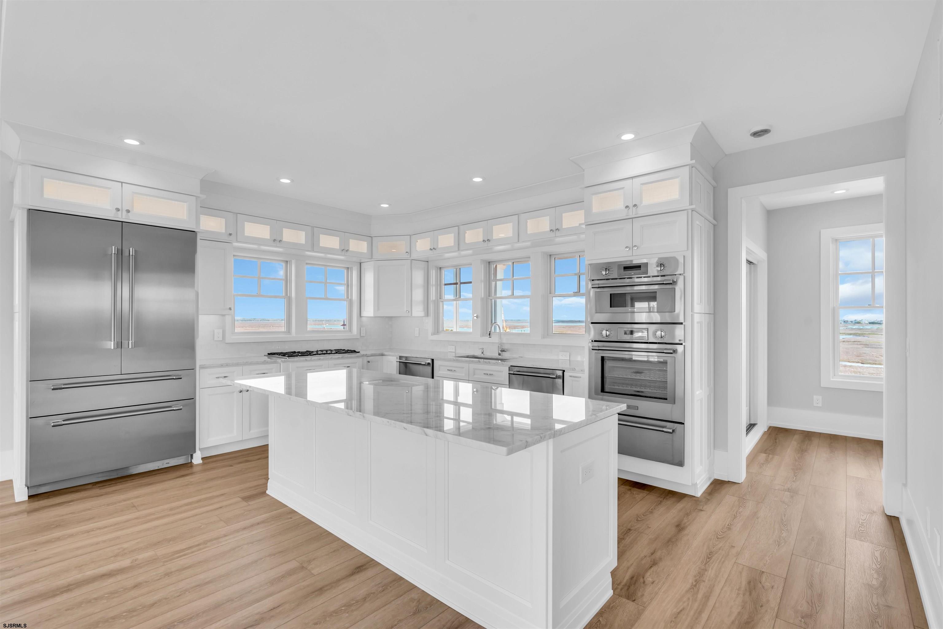 117 Taylor Avenue Strathmere, NJ 08248 - Photo 27 of 70 a kitchen with kitchen island white cabinets and stainless steel appliances