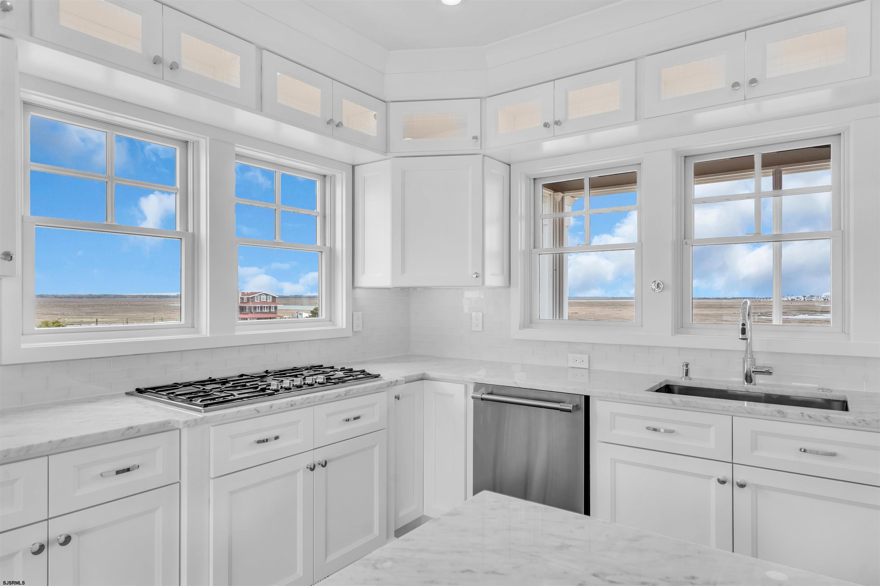 117 Taylor Avenue Strathmere, NJ 08248 - Photo 29 of 70 a kitchen with granite countertop white cabinets stainless steel appliances and a window
