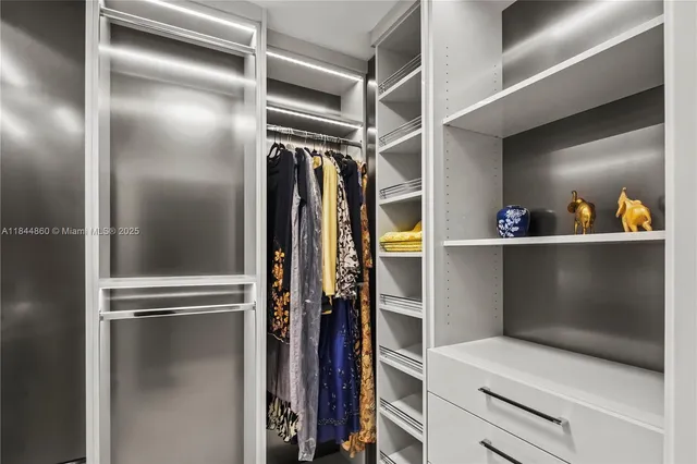 a view of walk in closet with clothes and shoes