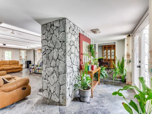 a living room with furniture and a potted plant