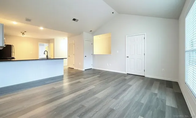 an empty room with wooden floor and a window