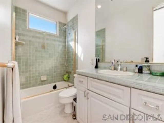 17381 Circa Oriente Rancho Santa Fe, CA 92067 - Photo 14 of 37 a bathroom with a granite countertop sink a toilet a mirror a bathtub and shower
