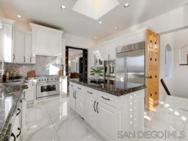 17381 Circa Oriente Rancho Santa Fe, CA 92067 - Photo 6 of 37 a kitchen with stainless steel appliances granite countertop a stove a sink and a refrigerator