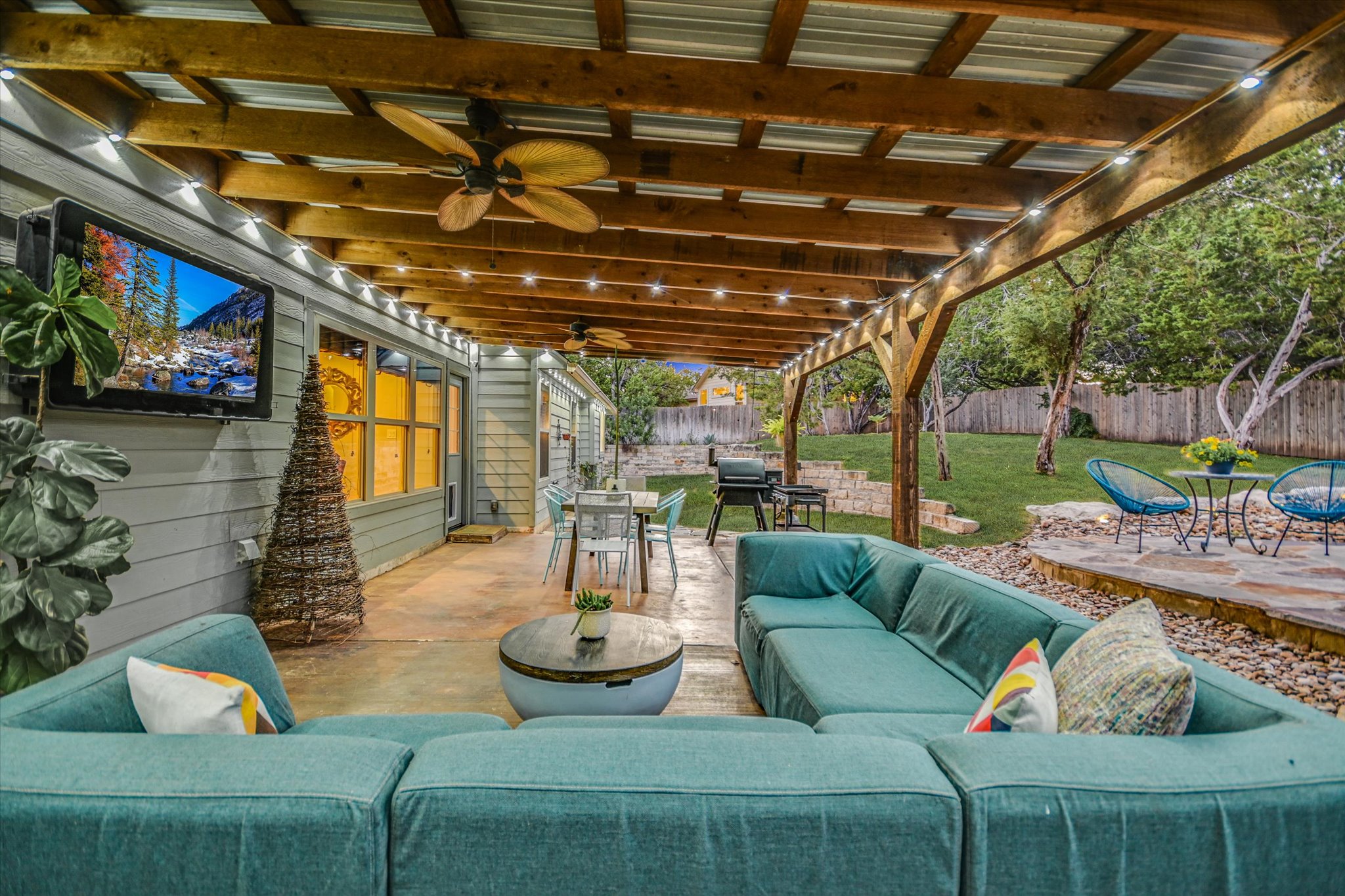 36 Ridgewood Circle Wimberley, TX 78676 - Photo 21 of 30 An inviting covered patio features a sturdy wood pergola overlooking the spacious backyard.