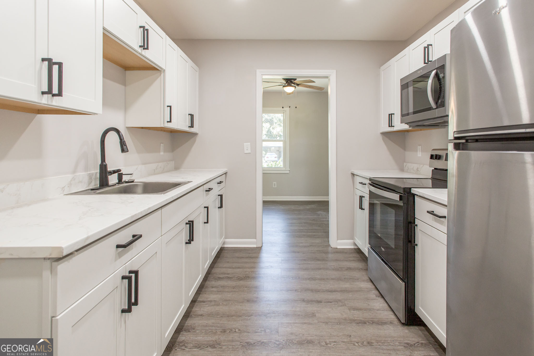 2312 Spurgeon Street Waycross, GA 31501 - Photo 12 of 20 a kitchen with stainless steel appliances granite countertop lots of counter top space and wooden floor