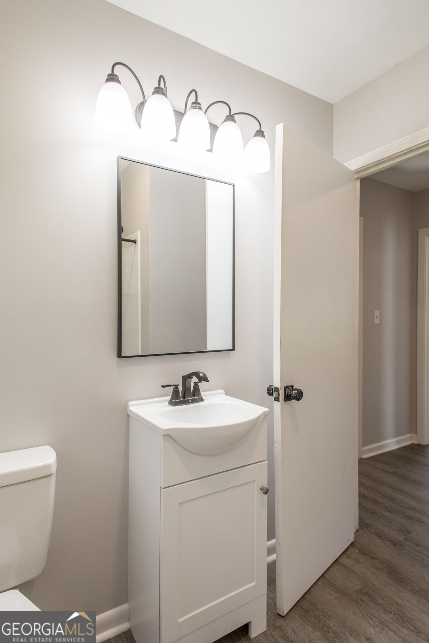 2312 Spurgeon Street Waycross, GA 31501 - Photo 18 of 20 a bathroom with a toilet sink and mirror
