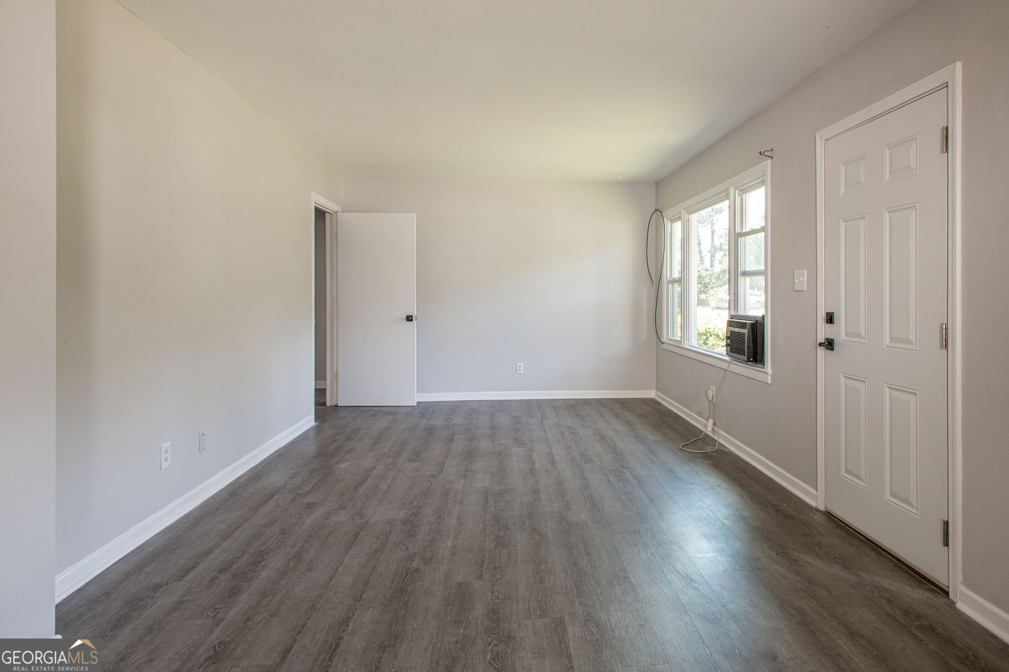2312 Spurgeon Street Waycross, GA 31501 - Photo 6 of 20 an empty room with wooden floor and windows