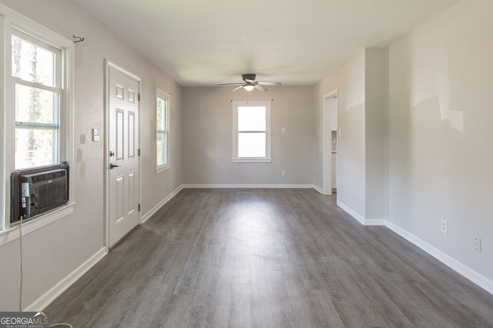 2312 Spurgeon Street Waycross, GA 31501 - Photo 7 of 20 an empty room with wooden floor and windows