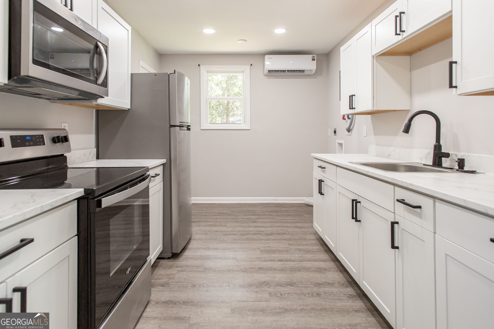 2312 Spurgeon Street Waycross, GA 31501 - Photo 9 of 20 a kitchen with stainless steel appliances granite countertop a stove a sink and a microwave