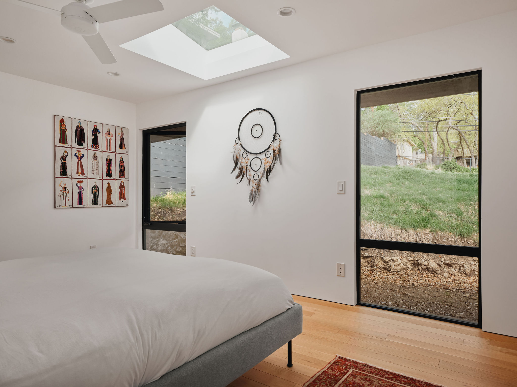 Undisclosed Address Austin, TX 78731 - Photo 17 of 26 Sunlight streams into the primary bedroom through large windows and an overhead skylight.