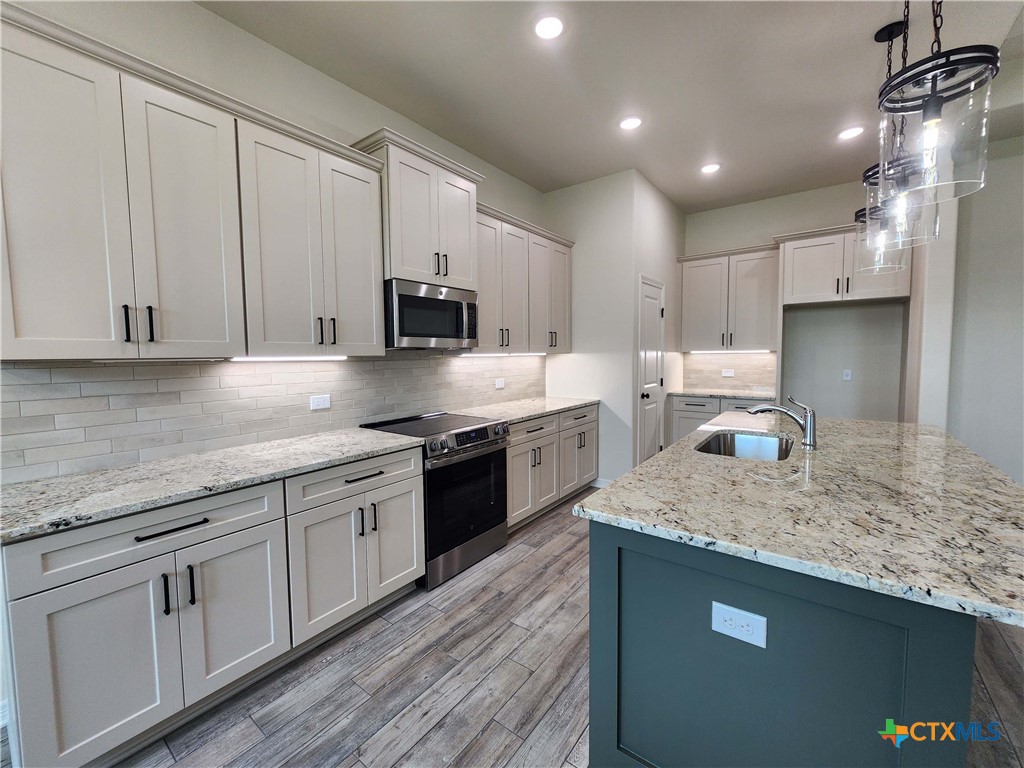 406 Talon Loop Salado, TX 76571 - Photo 8 of 31 a kitchen with stainless steel appliances granite countertop a sink stove and cabinets