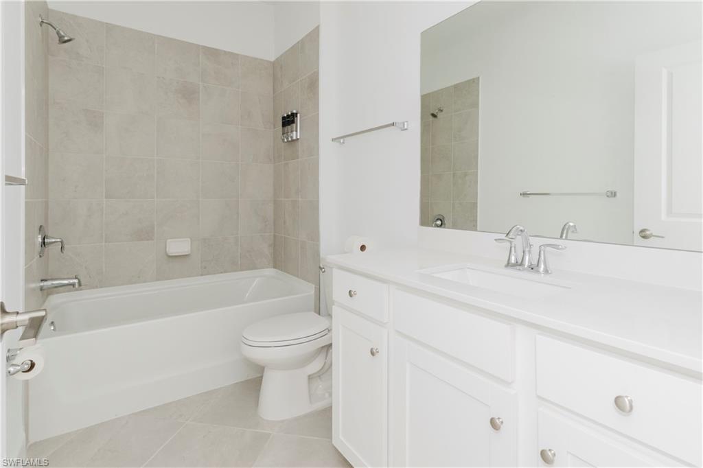 9099 Leatherwood Loop Lehigh Acres, FL 33936 - Photo 12 of 30 a bathroom with a bathtub shower sink mirror and toilet