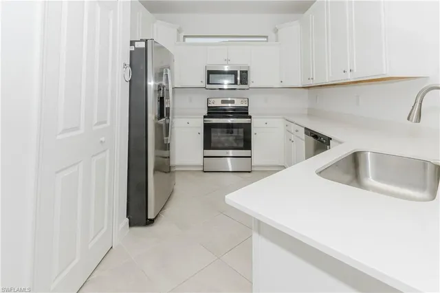 a kitchen with a refrigerator sink and cabinets