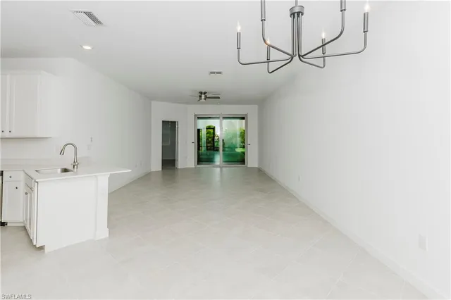 a view of a kitchen with a sink and chandelier