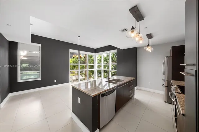a living room with stainless steel appliances kitchen island furniture and a chandelier
