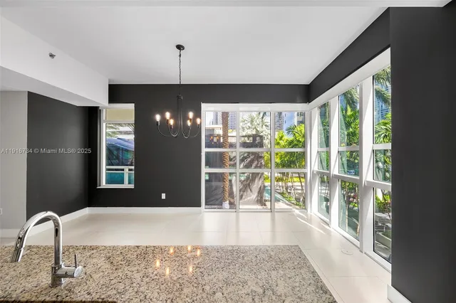 a view of a hallway with furniture and chandelier