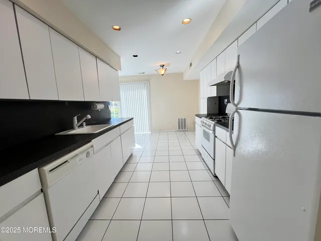 a kitchen with stainless steel appliances a refrigerator sink and cabinets