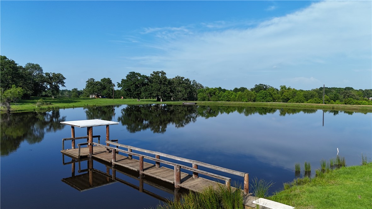 a view of a lake with couches and wooden fence