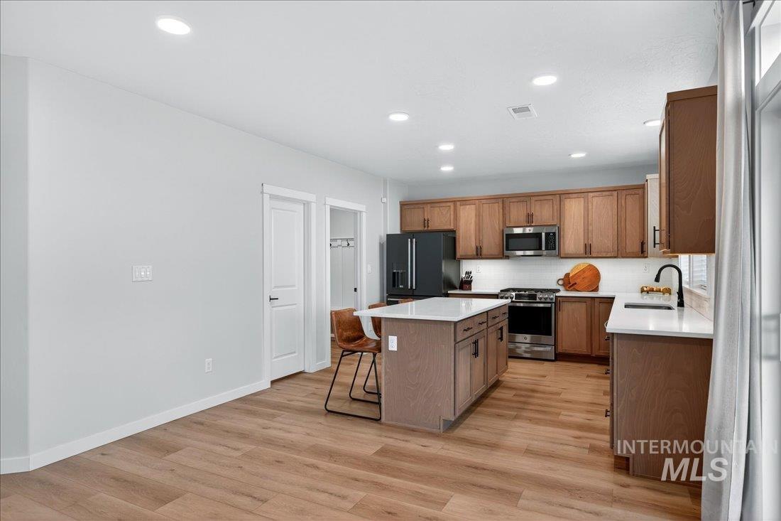 1993 North Perth Court Middleton, ID 83644 - Photo 17 of 45 Kitchen featuring stainless steel appliances, a kitchen island, a breakfast bar area, light wood-style flooring, and recessed lighting