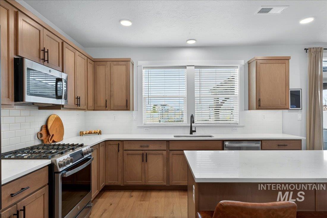 1993 North Perth Court Middleton, ID 83644 - Photo 19 of 45 Kitchen with stainless steel appliances, light wood finished floors, light stone countertops, wood finish cabinets, and recessed lighting