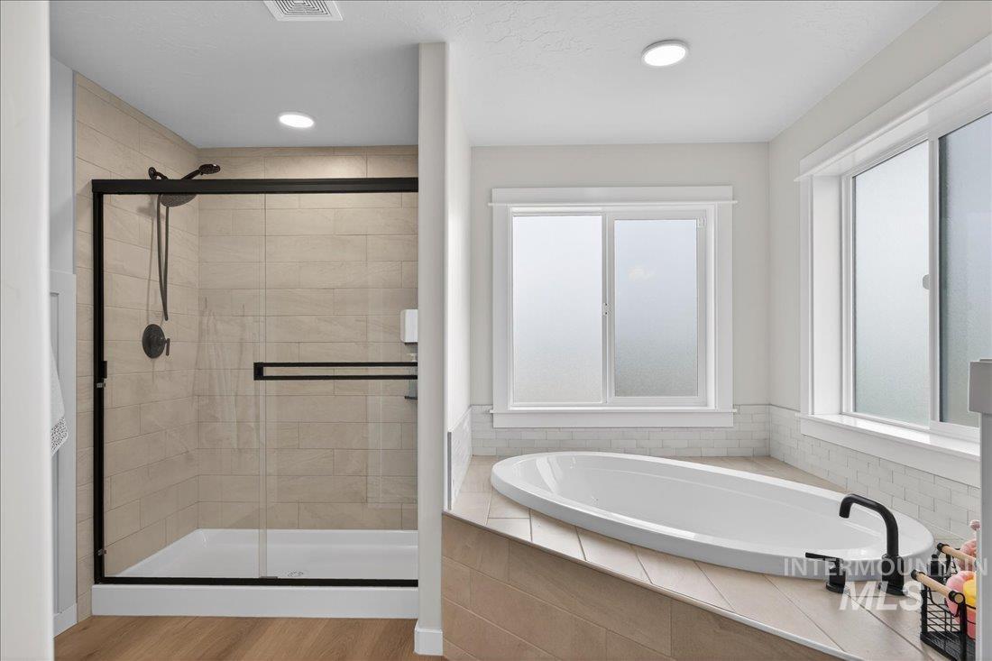 1993 North Perth Court Middleton, ID 83644 - Photo 25 of 45 Full bath with a stall shower, a garden tub, light wood-style flooring, and recessed lighting