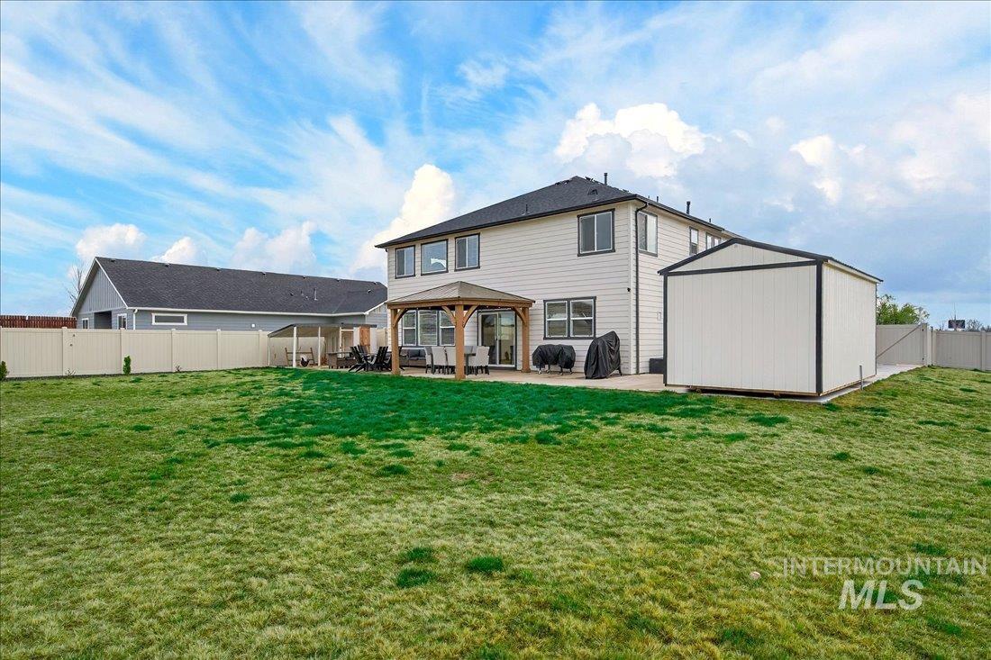 1993 North Perth Court Middleton, ID 83644 - Photo 34 of 45 Rear view of house featuring a fenced backyard, a patio, a gazebo, and a storage shed