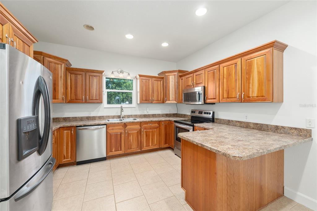 4735 Southeast 112th Street Road Belleview, FL 34420 - Photo 24 of 73 a kitchen with stainless steel appliances granite countertop a sink dishwasher stove and refrigerator