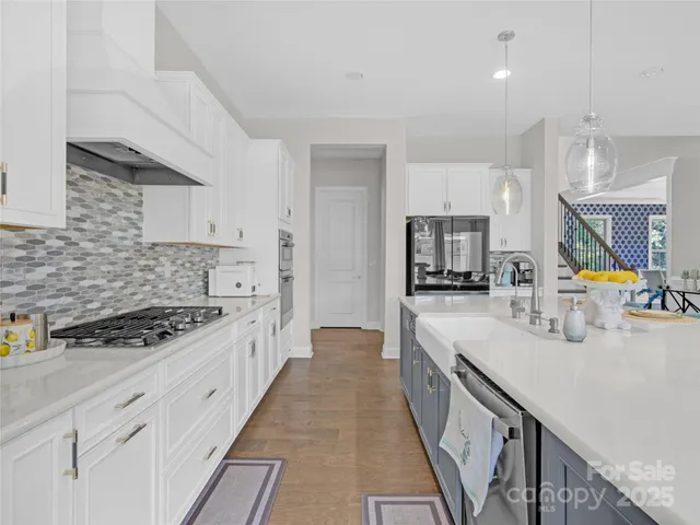 a large white kitchen with stainless steel appliances