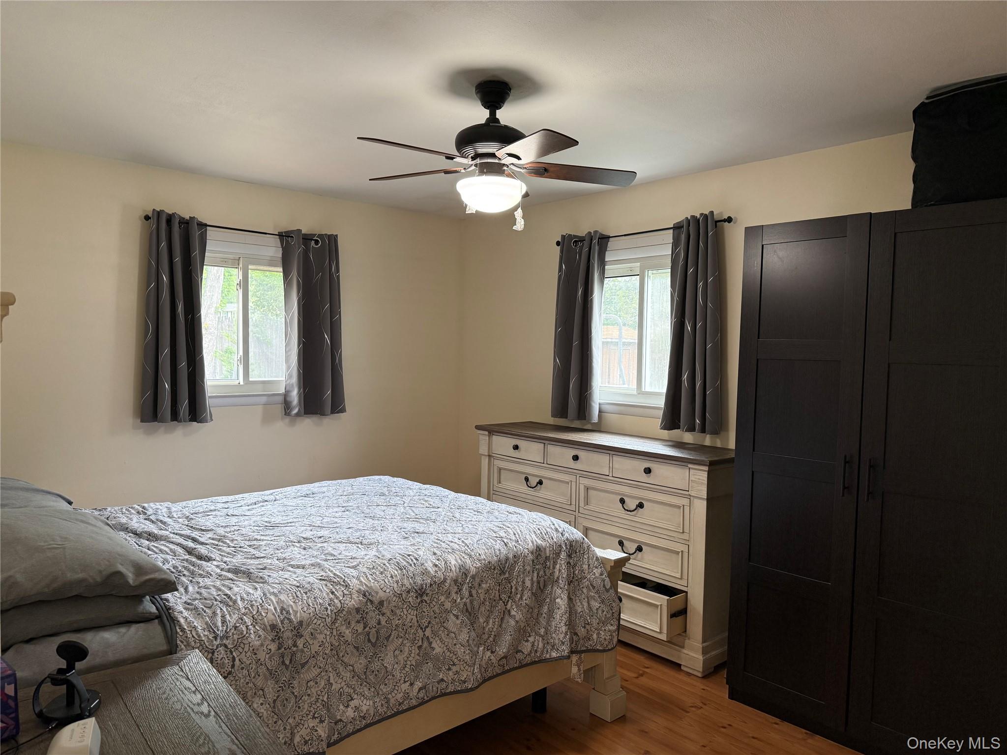 161 Hawkins Road Centereach, NY 11720 - Photo 13 of 16 a bedroom with a large bed and a chandelier