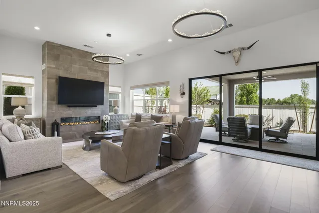 a living room with furniture a flat screen tv and floor to ceiling window
