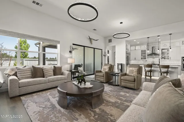 a living room with furniture kitchen view and a large window