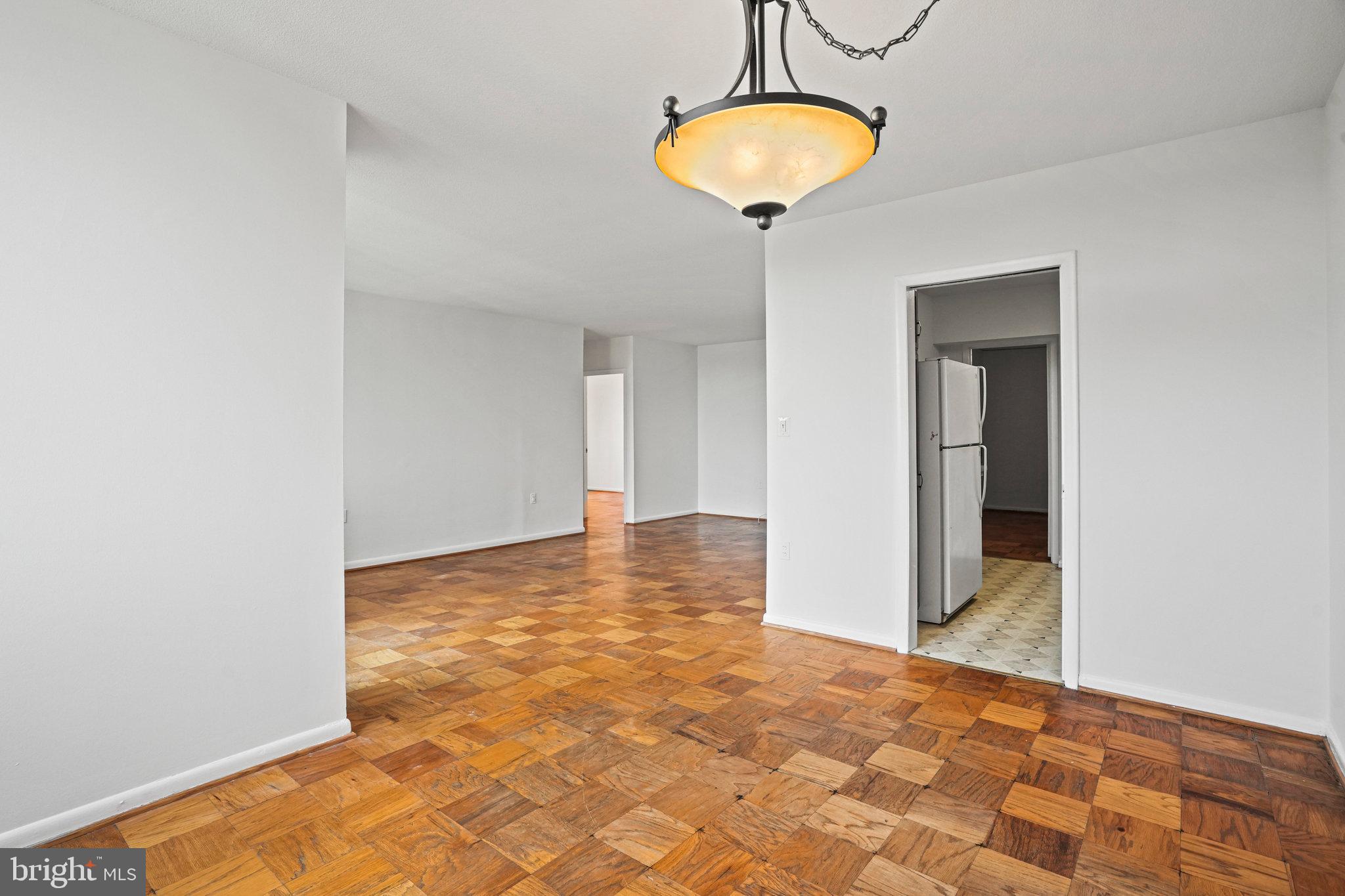 4242 East W Highway, Unit 605 Chevy Chase, MD 20815 - Photo 15 of 46 a view of a hallway with a chandelier
