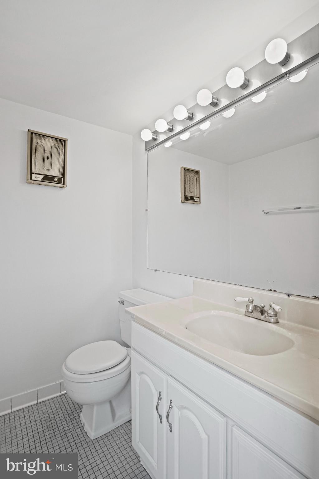 4242 East W Highway, Unit 605 Chevy Chase, MD 20815 - Photo 25 of 46 a bathroom with a sink a toilet and a mirror